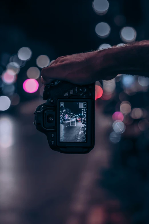 someone taking a picture with their camera at night