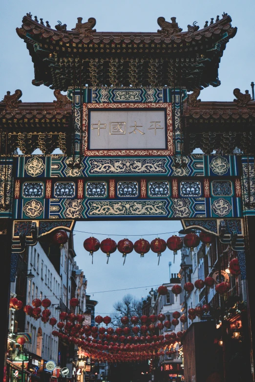 an oriental gate that has red lanterns hanging from it