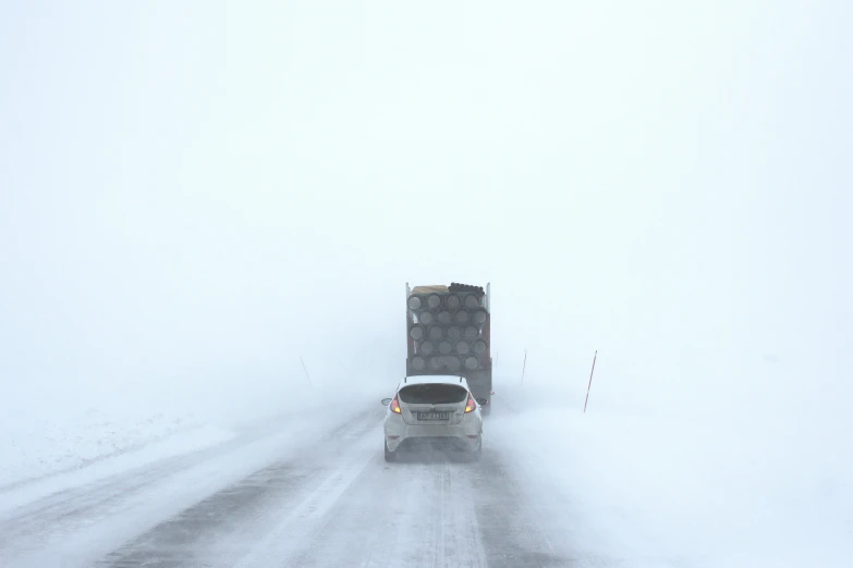 there is a large truck driving down the street in snow