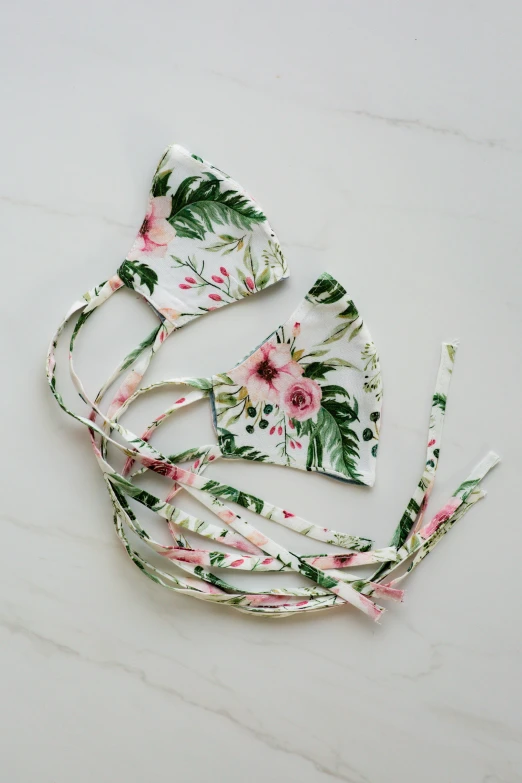 a white floral headband and a pink flowered bikini top