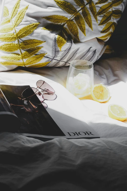 a yellow book and a glass sitting on a bed