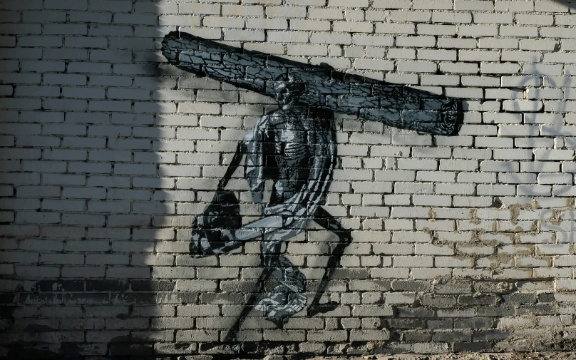 a mural of jesus holding a cross on the side of a brick building