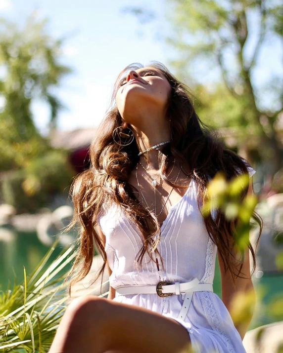 a woman is sitting on grass in the sun