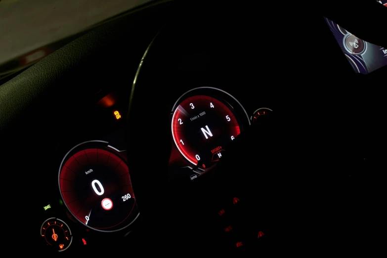 an electronic gauges of a car dashboard and some lights