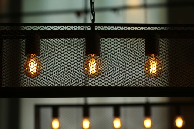 four lights that are hanging from a metal fixture