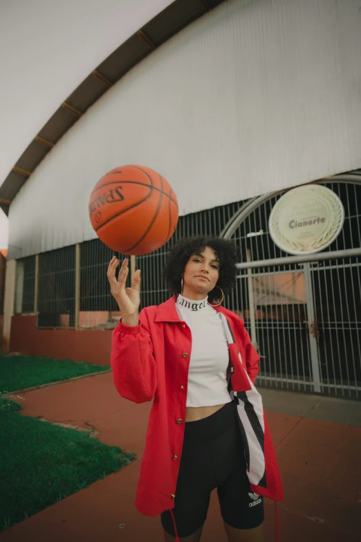 a woman holding a basketball with one hand