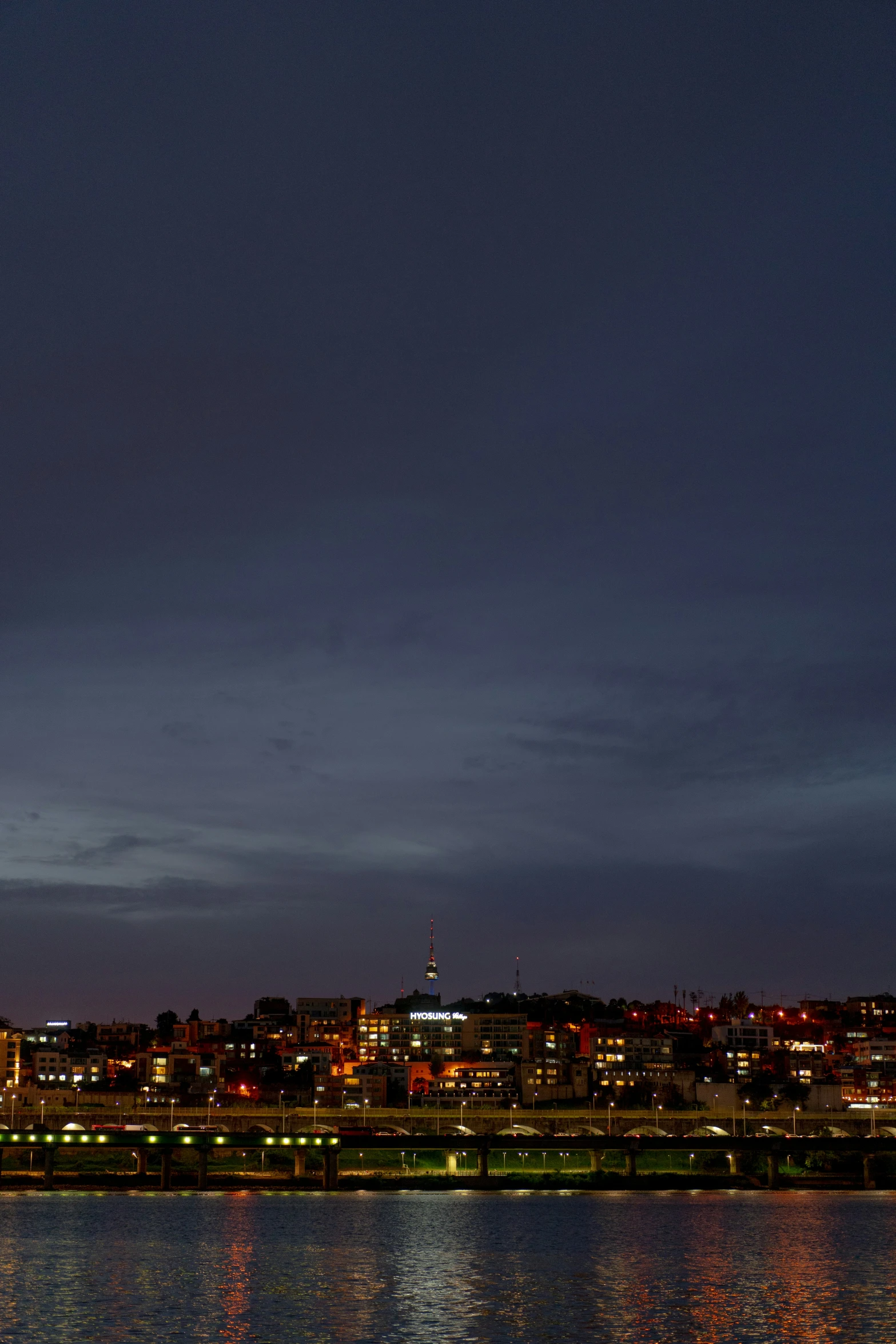 a bright clock tower rises above the city lights