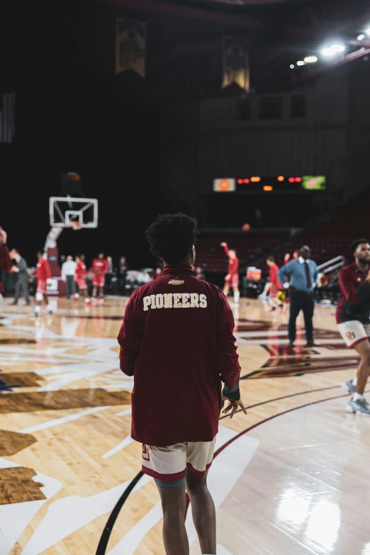 the man in maroon jacket is playing basketball