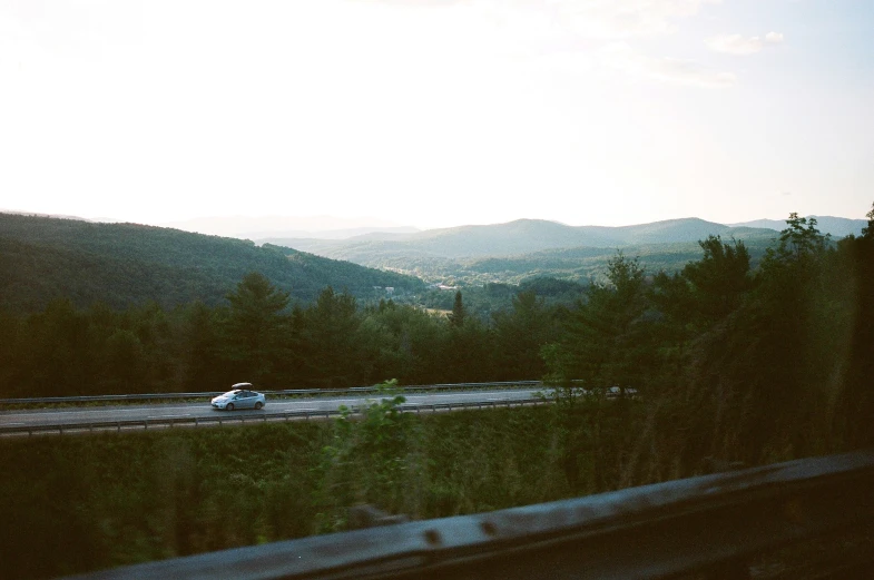 the car is on the road surrounded by the mountains