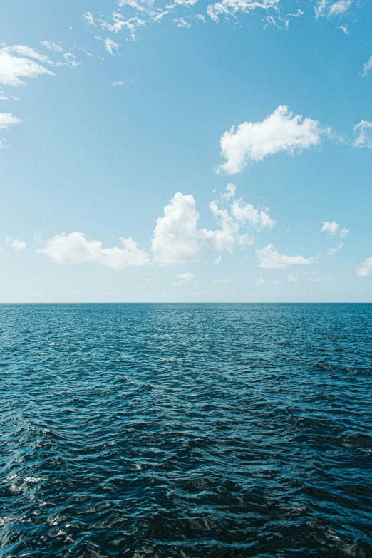 some big blue skies and the water with no waves