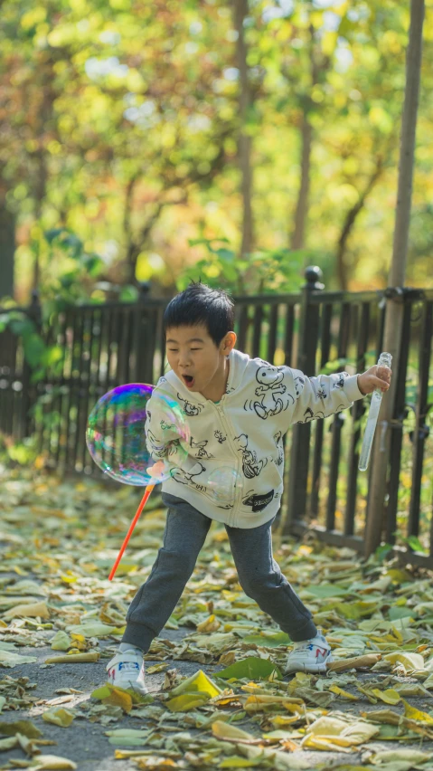 a little boy playing with a bubble wand