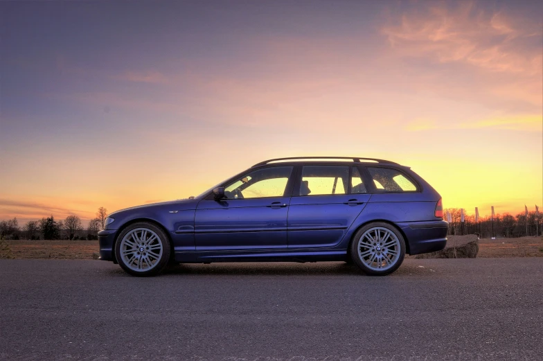 the blue bmw was parked in a gravel lot