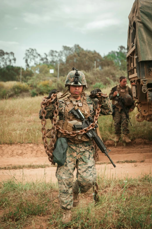 an armed man standing in the dirt, holding a rifle