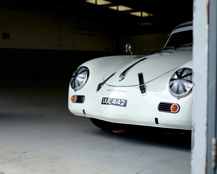 a white vintage car parked in the garage