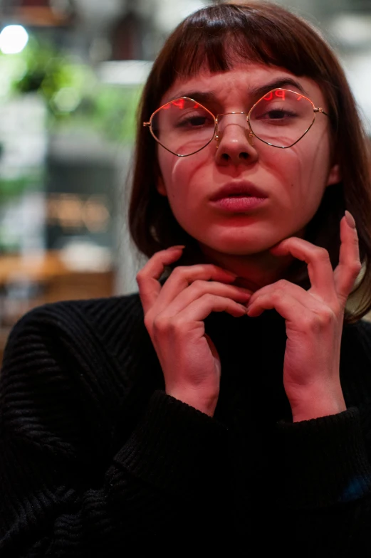 the girl has her hands around her neck, wearing glasses