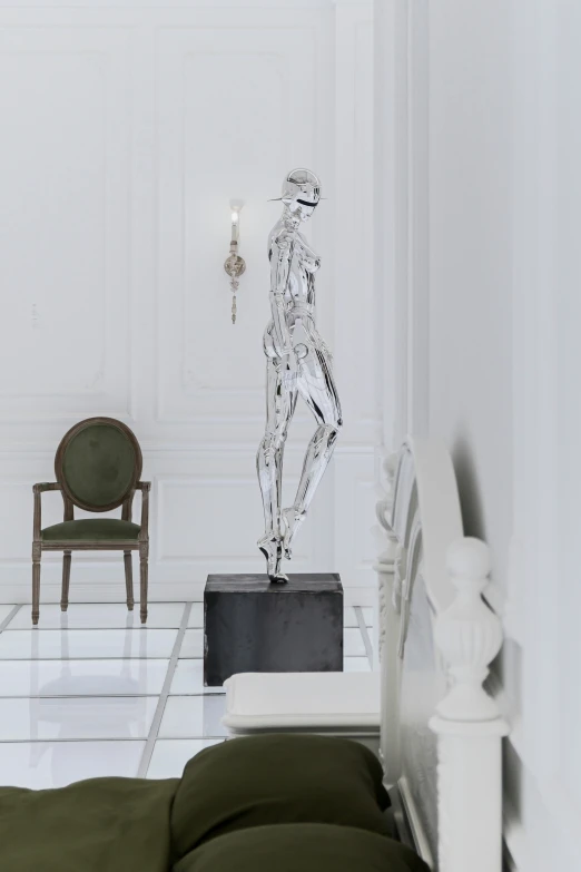 a white room with a statue on display and chair in it