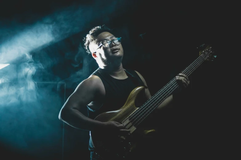 a man playing guitar in the dark at a concert