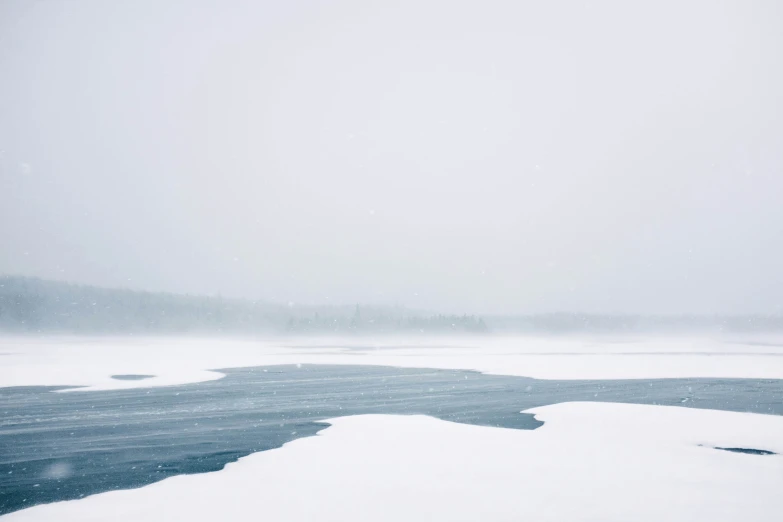 a foggy day with a lone boat and some snow