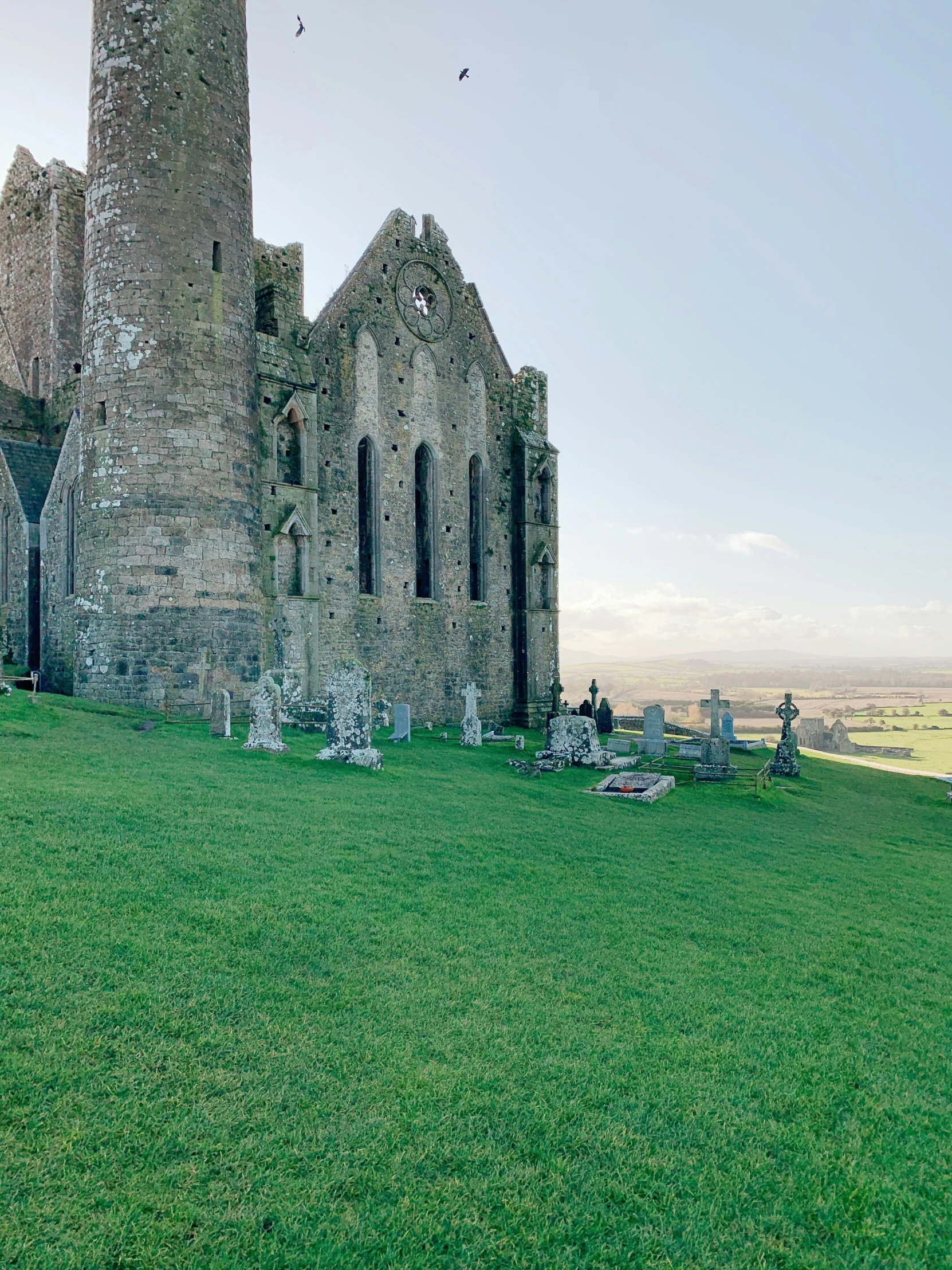 ruins in an old church, one with broken windows and a field