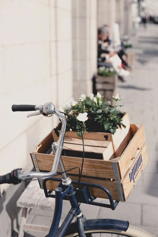 a bicycle has a wooden crate with flowers in it