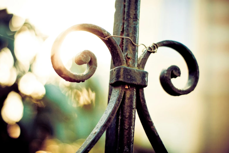 an antique iron gate with decorative swirls and metal bars