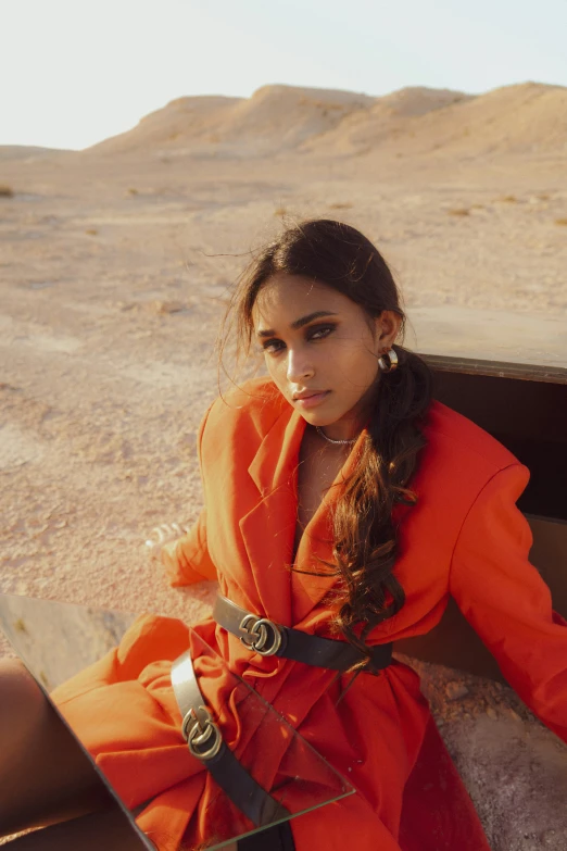 a  wearing an orange outfit sitting on top of a bench