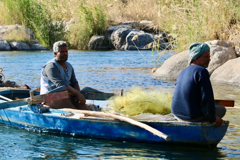 a couple of men on a small boat in the water