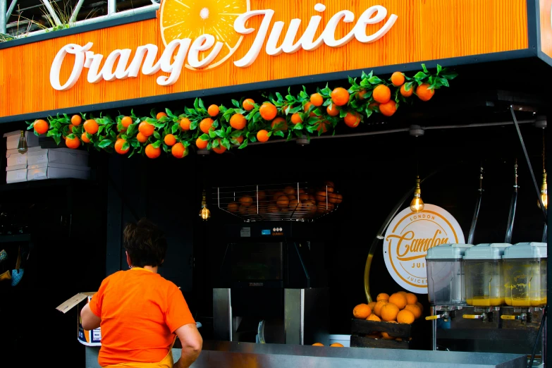 a man in orange shirts at an orange juice shop