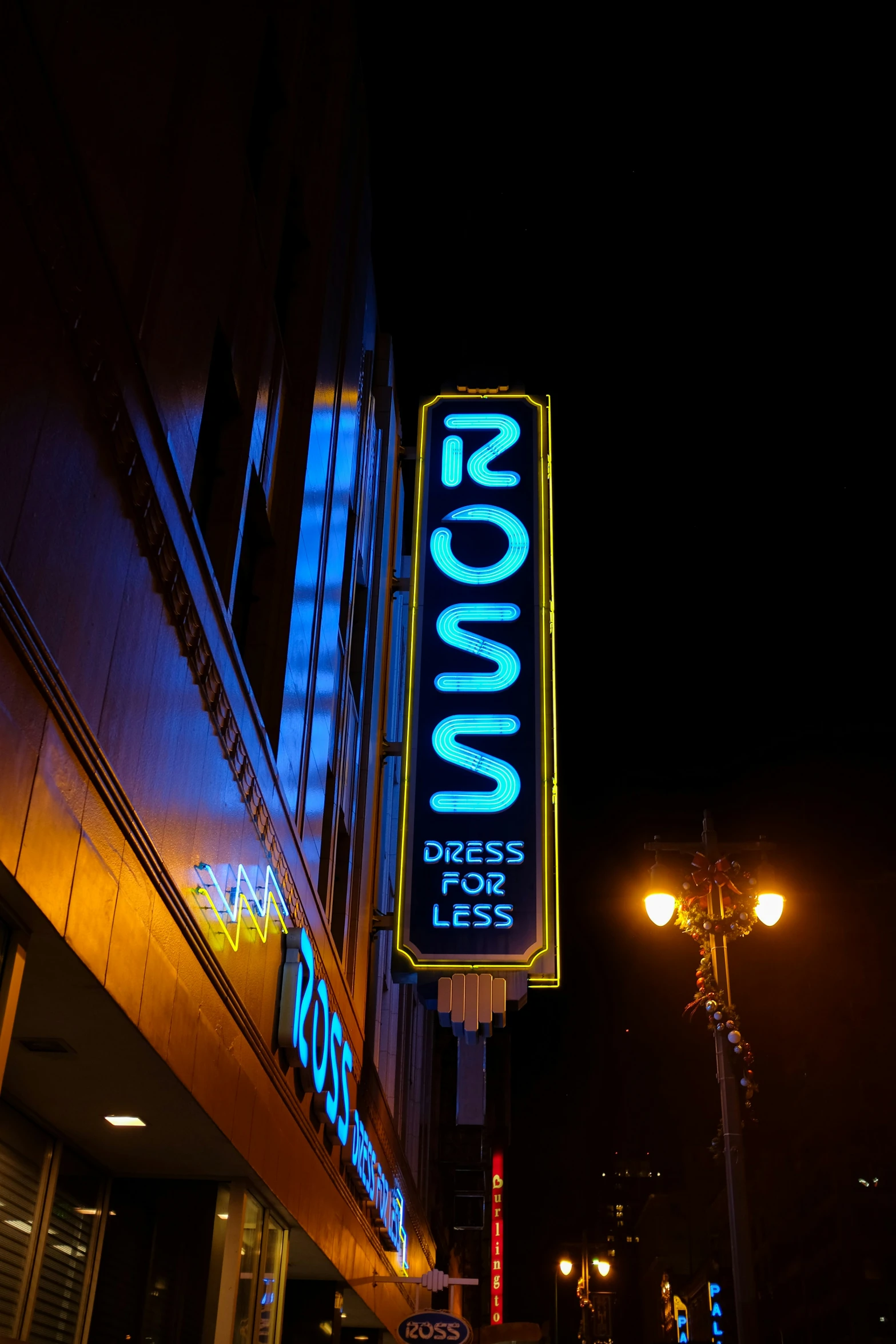 a neon sign on a tall building in a city