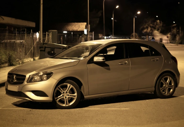 a silver car parked in the street at night