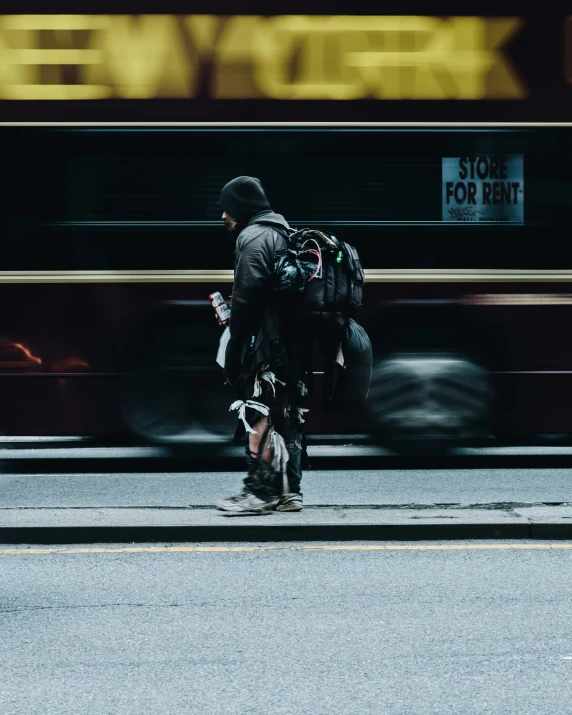 a man with back pack and luggage going down the street