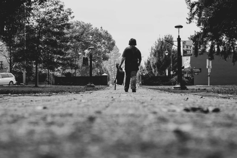 a black and white image of a man walking down the street