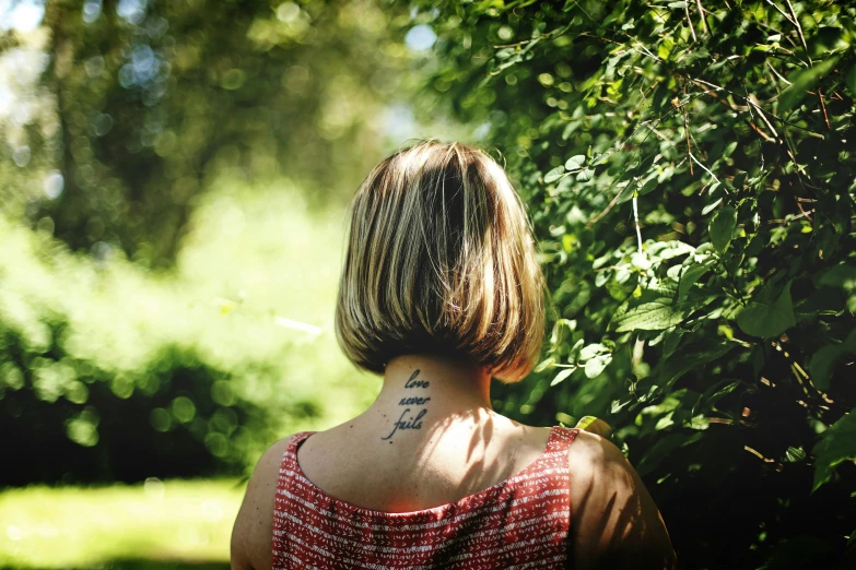 the back of a woman's neck with a tattoo on it