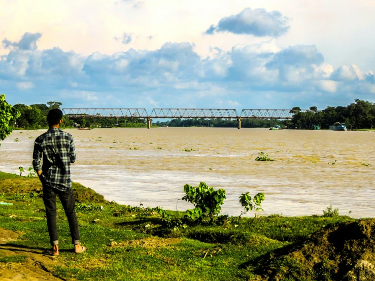 a man is walking on a path near the river