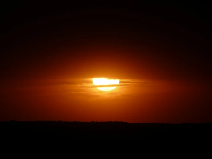 a plane flying over the sun during a beautiful sunset