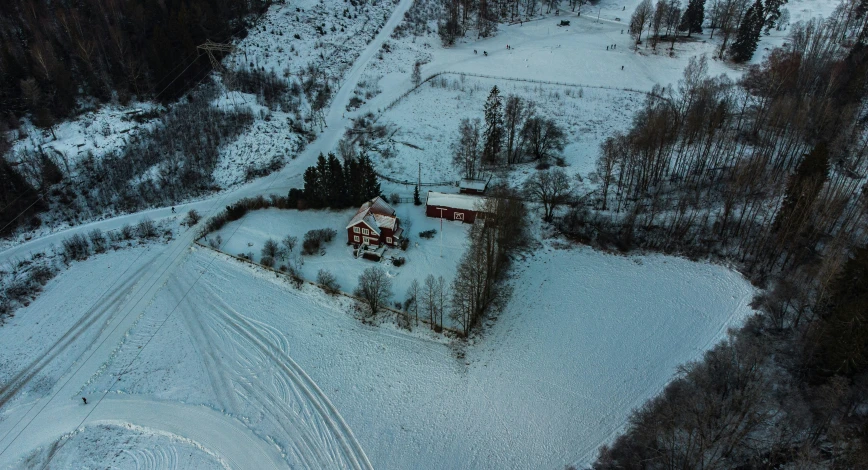 a snow covered wooded area and two large houses