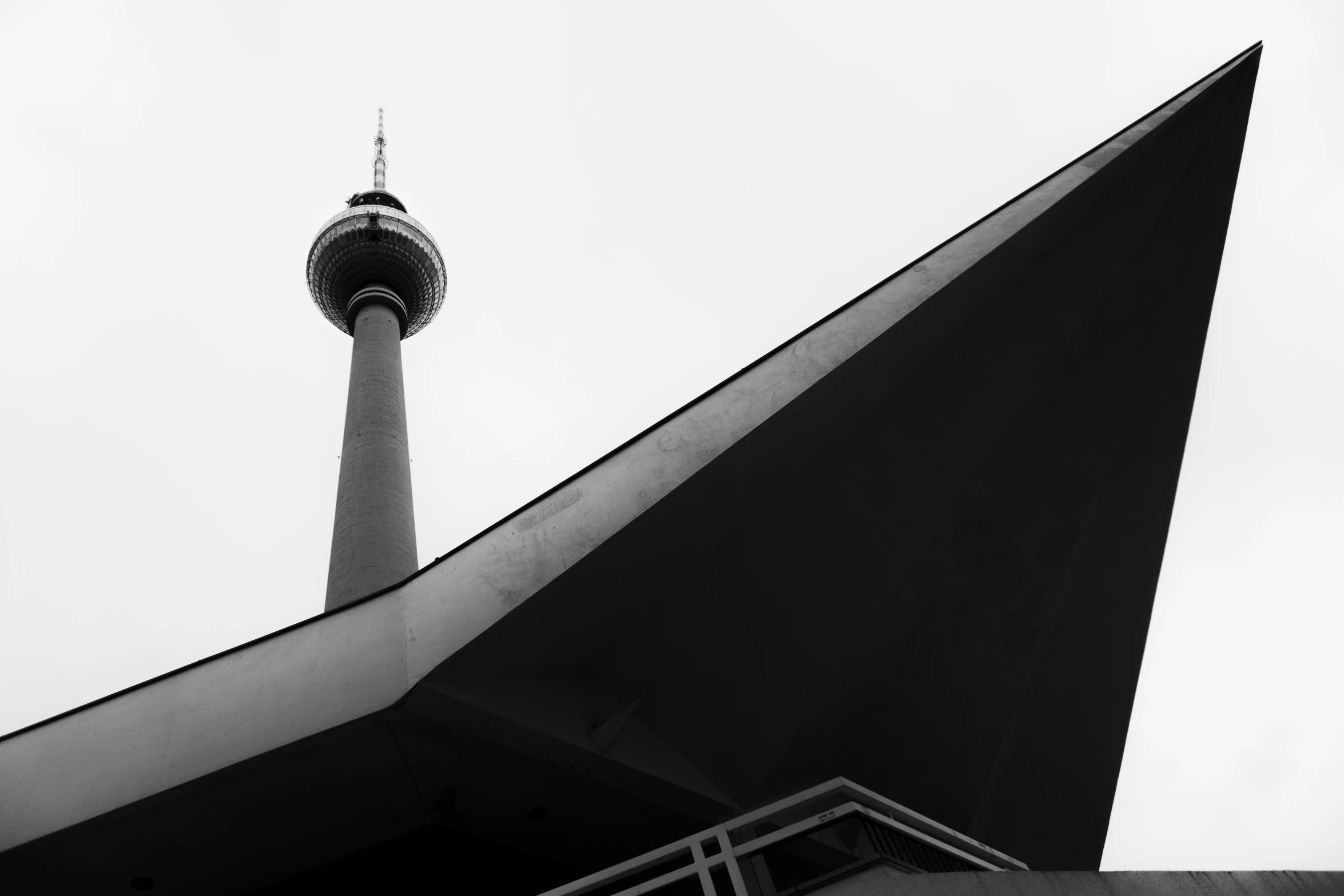 a building is seen from the ground with a tall tower in the distance