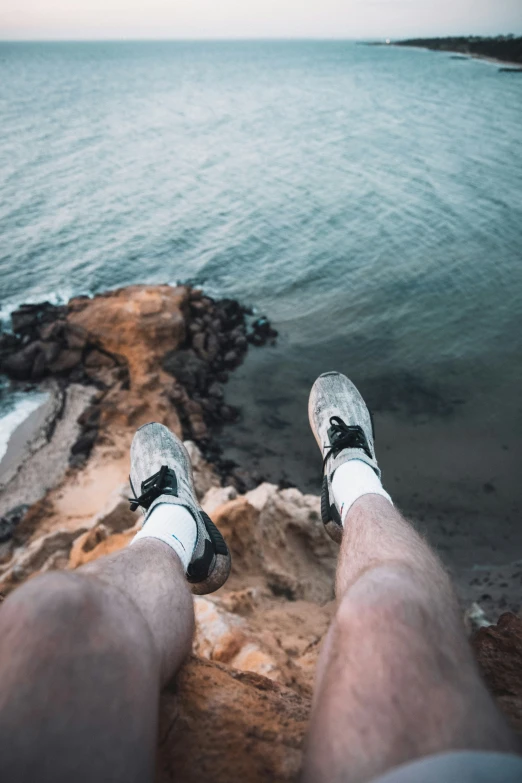 a man looking at the ocean with his feet up