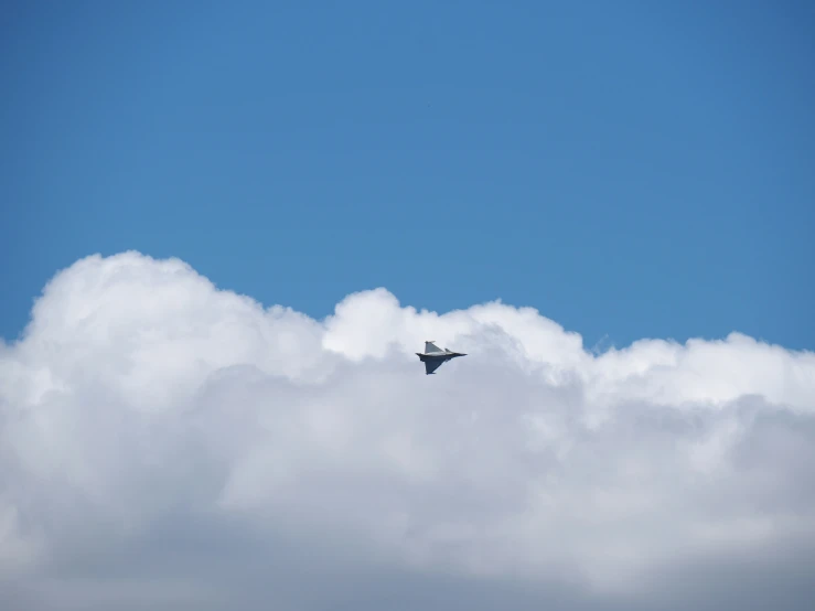 a small airplane flying in the sky on cloudy day