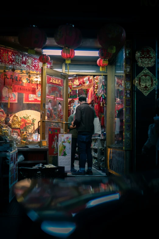 people looking at chinese new year decorations on display in an outside room