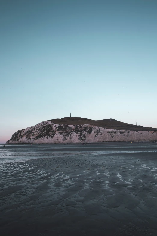 an island off the coast is shown with waves in the foreground