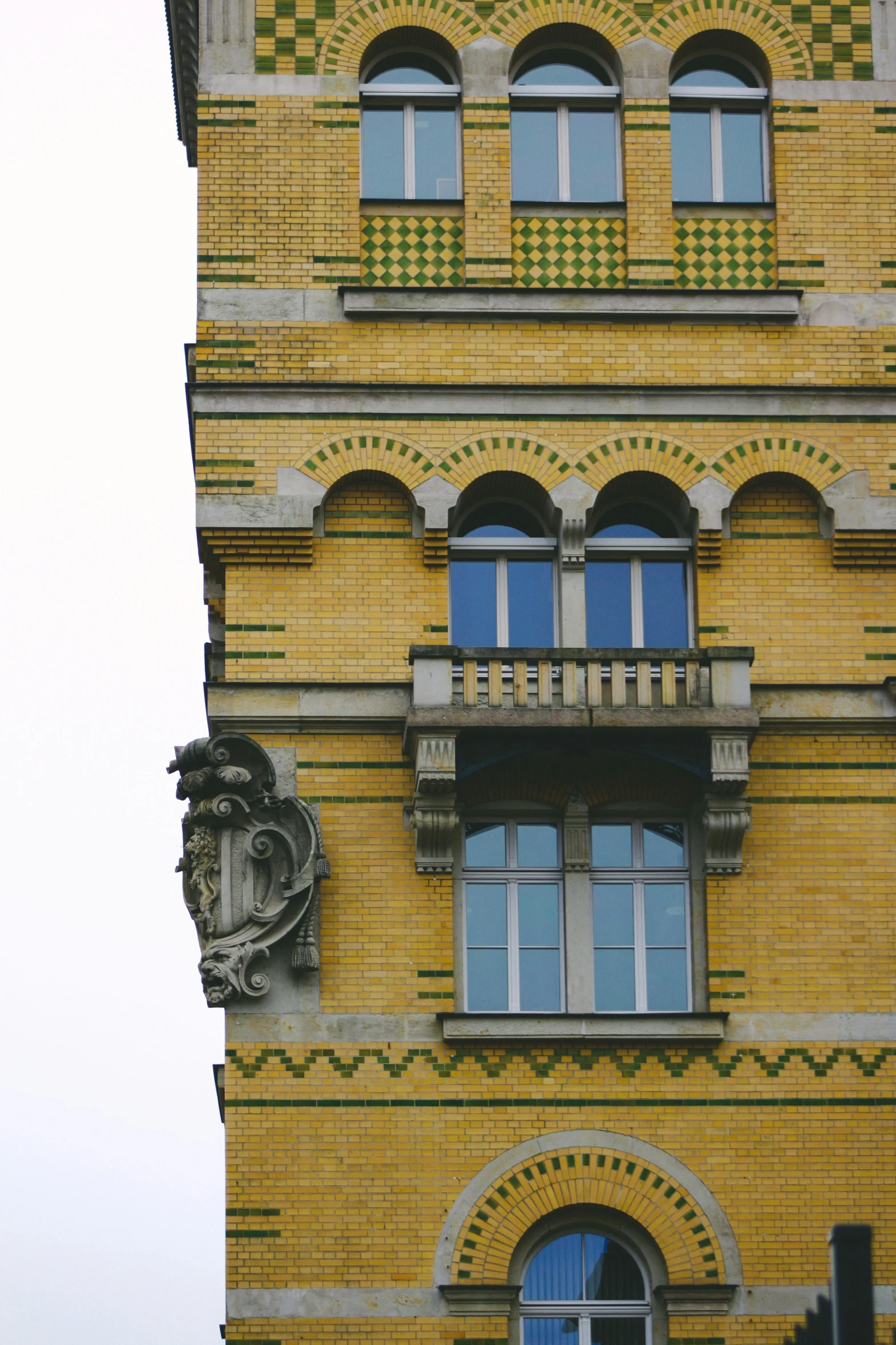 the front of an old building with a balcony and round windows