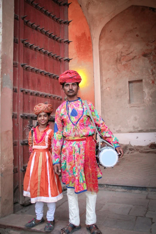 a man standing next to a girl in an elaborate dress