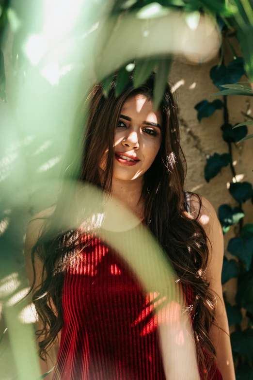 a woman posing in a dress next to a wall