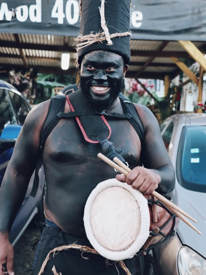 a man wearing black has drums in his hands