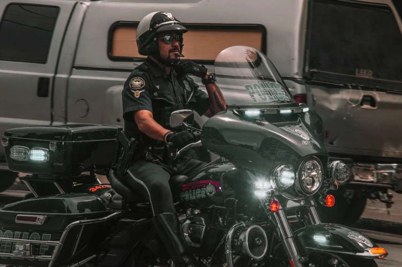 a police officer sits on his motorcycle outside a bus