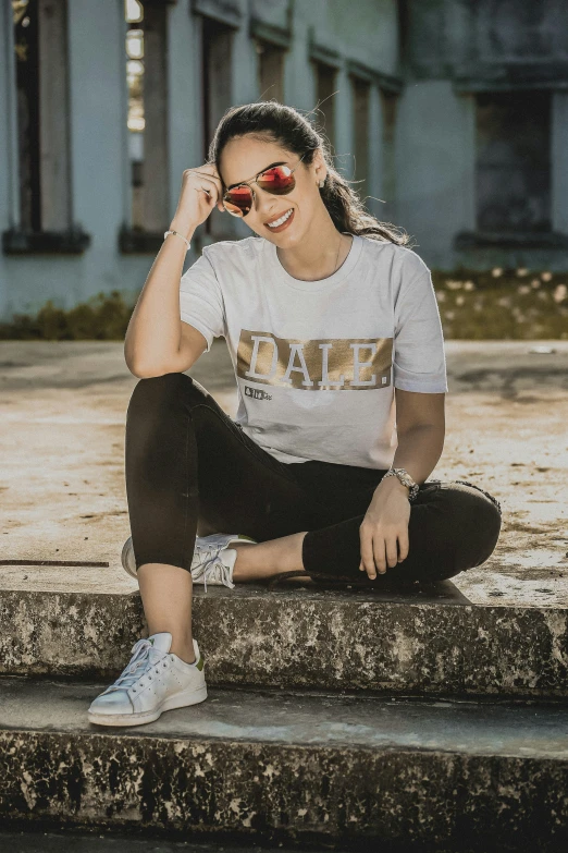 a woman with sunglasses is sitting on steps