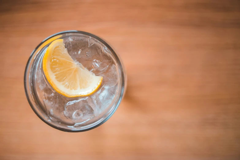 a glass filled with water with a lemon slice in it