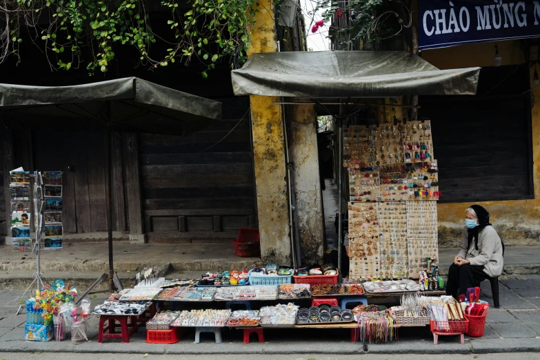 a woman sitting in a chair near a store selling gifts