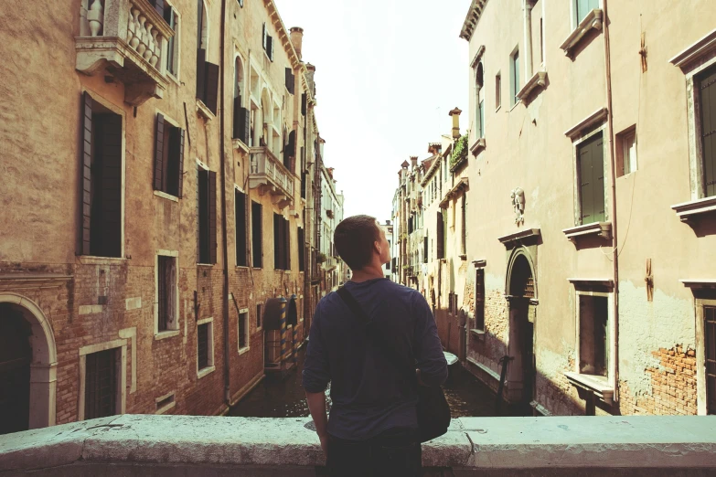 person with back to the camera looking down at a narrow canal